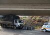Caminhão com carga de carvão fica preso em estrutura de viaduto em Lafaiete