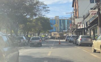 Carreta com carga de postes “quebra” na avenida em Lafaiete e interdita o trânsito